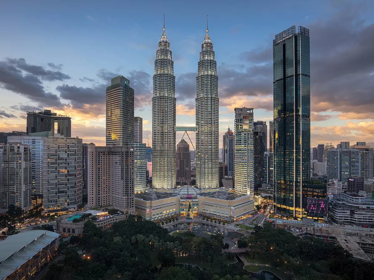 The Petronas Twin Towers rising above the Kuala Lumpur skyline at dusk
